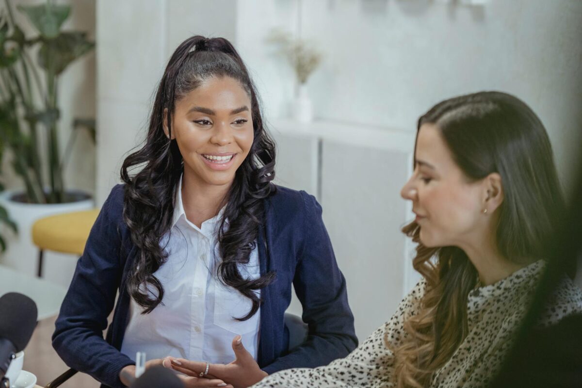 Cheerful diverse women having conversation during interview